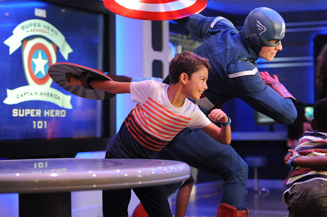 Un garçon pose à côté de Captain America