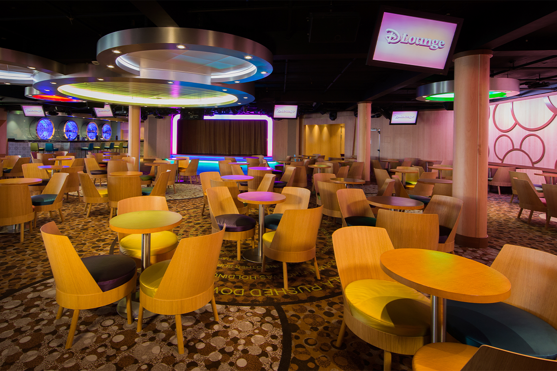 Un salon coloré avec de grands luminaires ronds, un motif de cercles et une scène