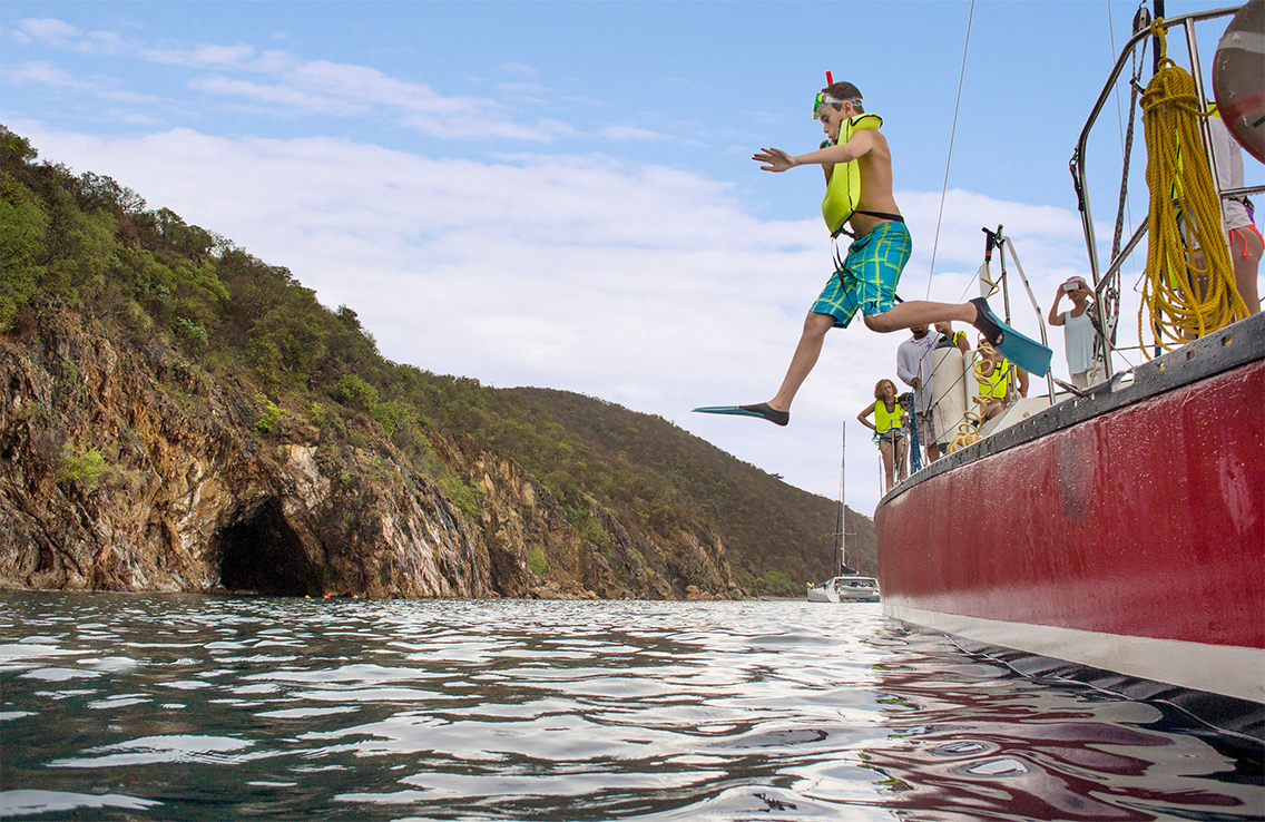 Deux plongeurs, main dans la main, flottent au-dessus d'une statue immergée de Mickey Mouse