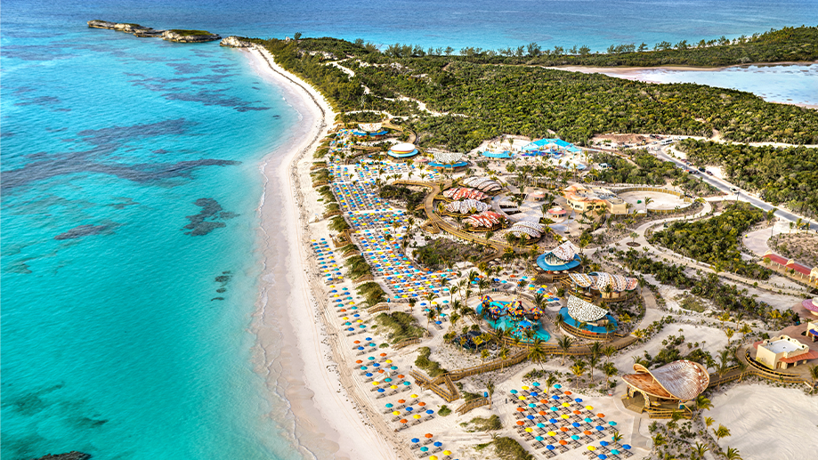 La côte d'une île tropicale luxuriante révèle plusieurs pavillons à grande échelle et une longue étendue de plage bordé de chaises longues