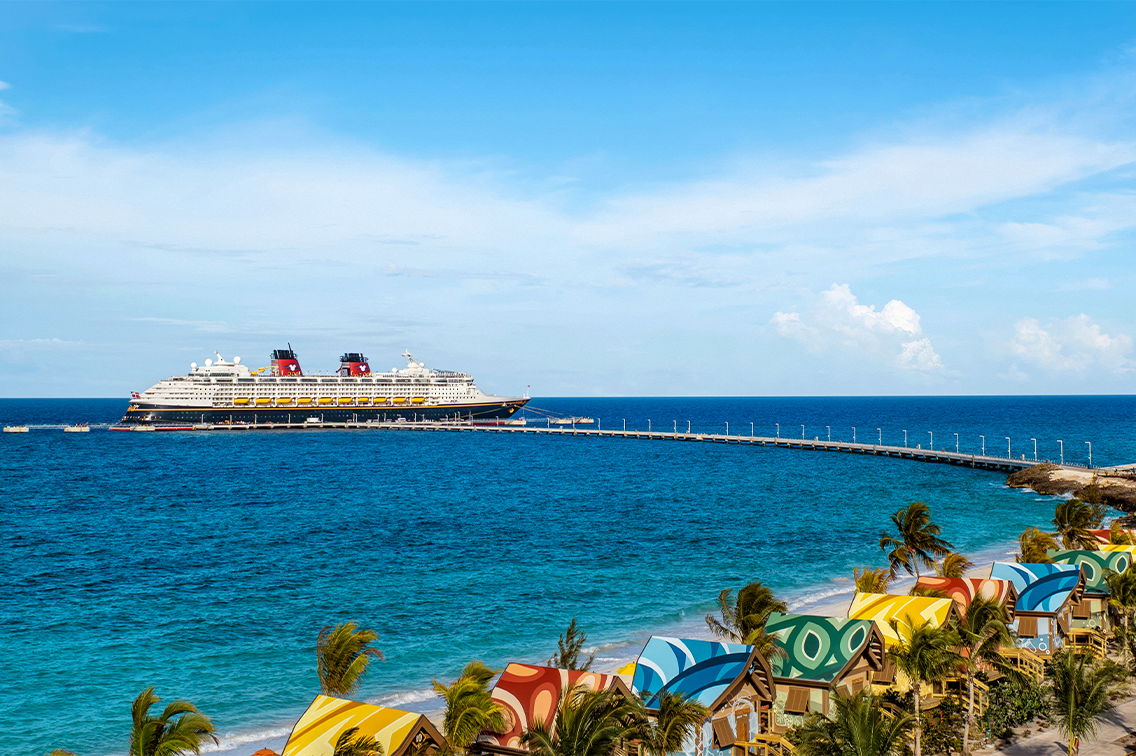 La côte d'une île tropicale luxuriante révèle plusieurs pavillons à grande échelle et une longue étendue de plage bordé de chaises longues