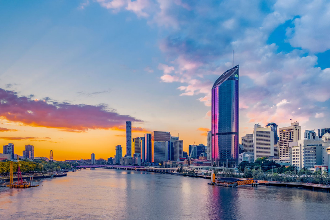 Une rivière tranquille avec une plage tropicale d un côté, et une ville cosmopolite de l autre