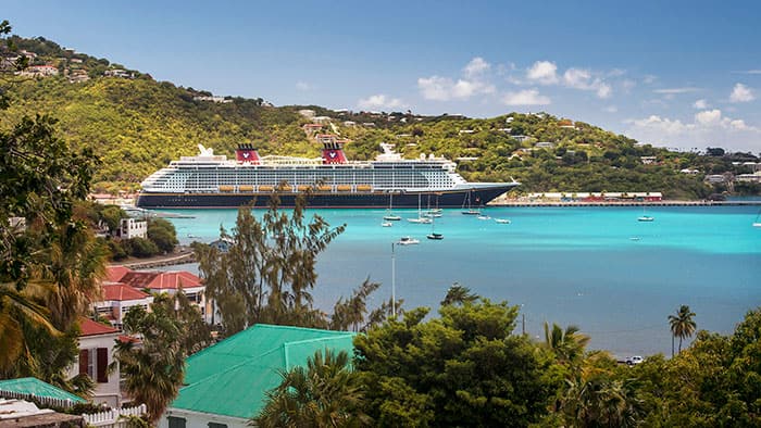Un navire de croisière Disney près d'une île avec des bâtiments et des arbres