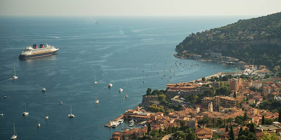 Un navire de croisière près d'une marina bondée, d'une ville et d'une montagne