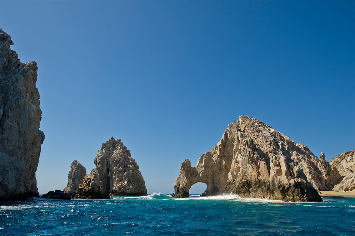 Une grande formation rocheuse dentelée avec une arche naturelle dans la Riviera mexicaine